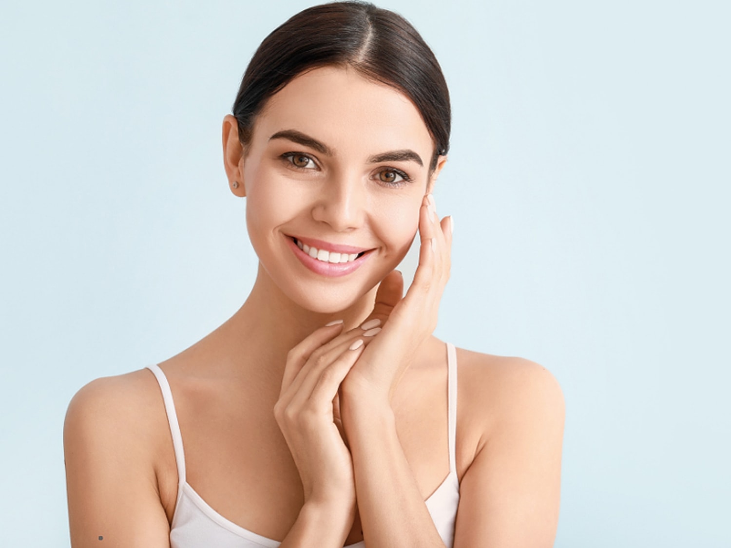 Smiling woman with clear skin on blue background.
