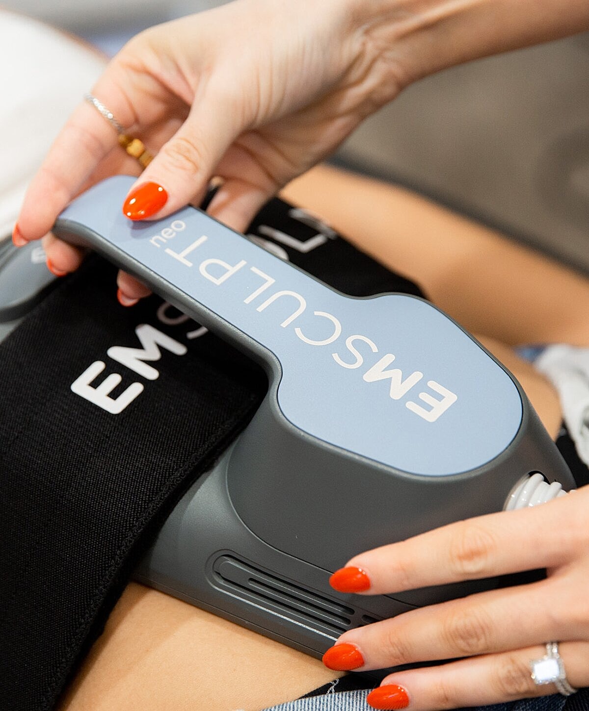 Emsculpt Neo device in use on abdomen.
