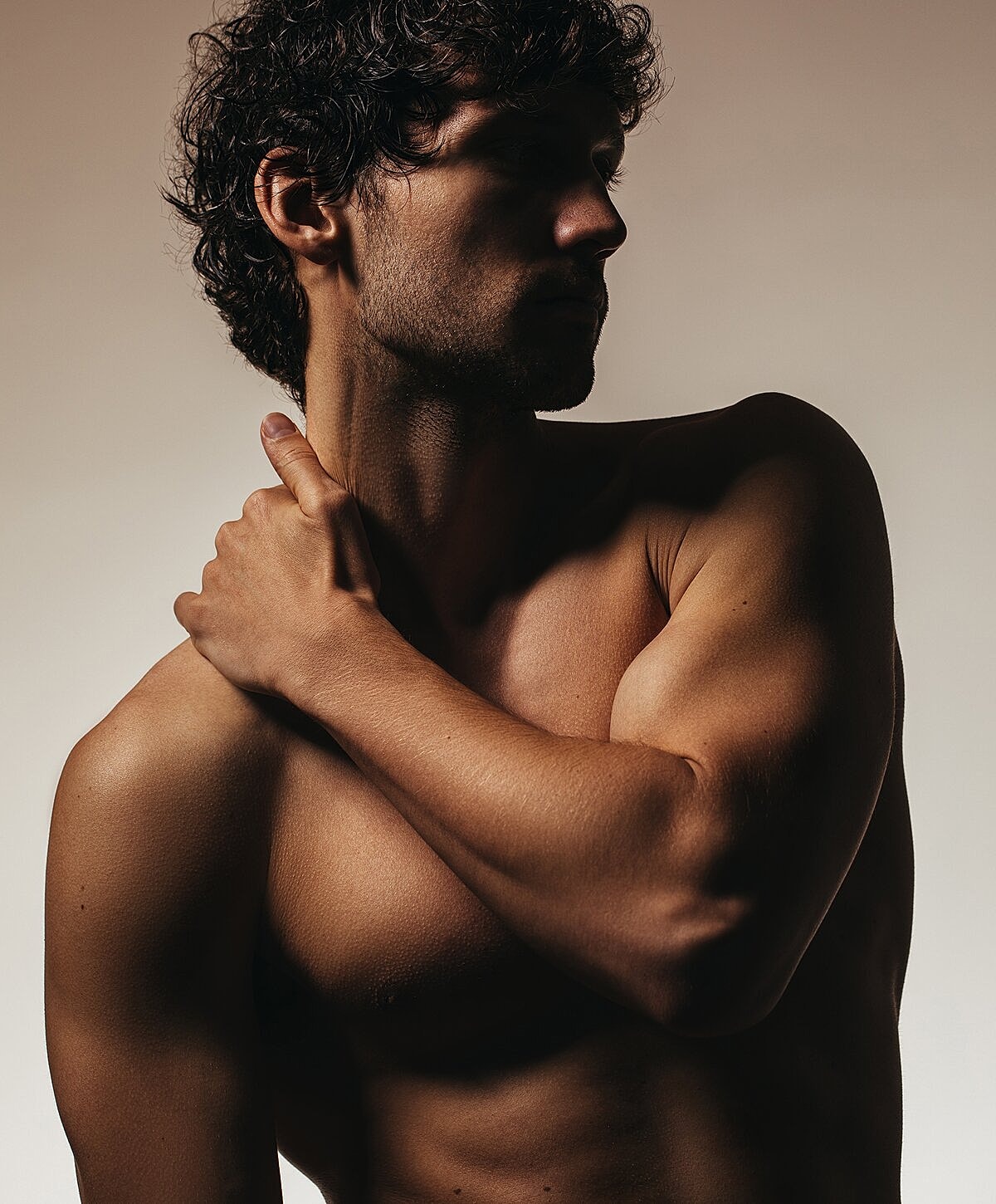 Male figure in shadow with bare shoulders.