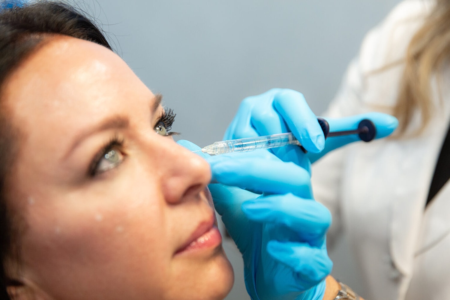 Administering cosmetic injection on a woman's face.