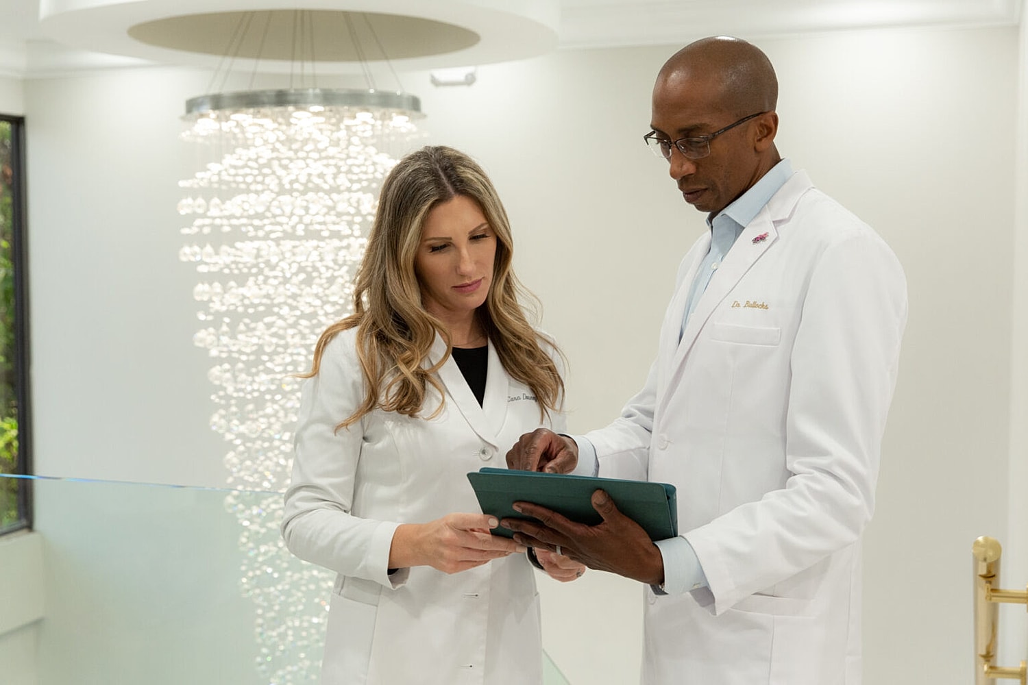 Medical professionals discussing information on a tablet.