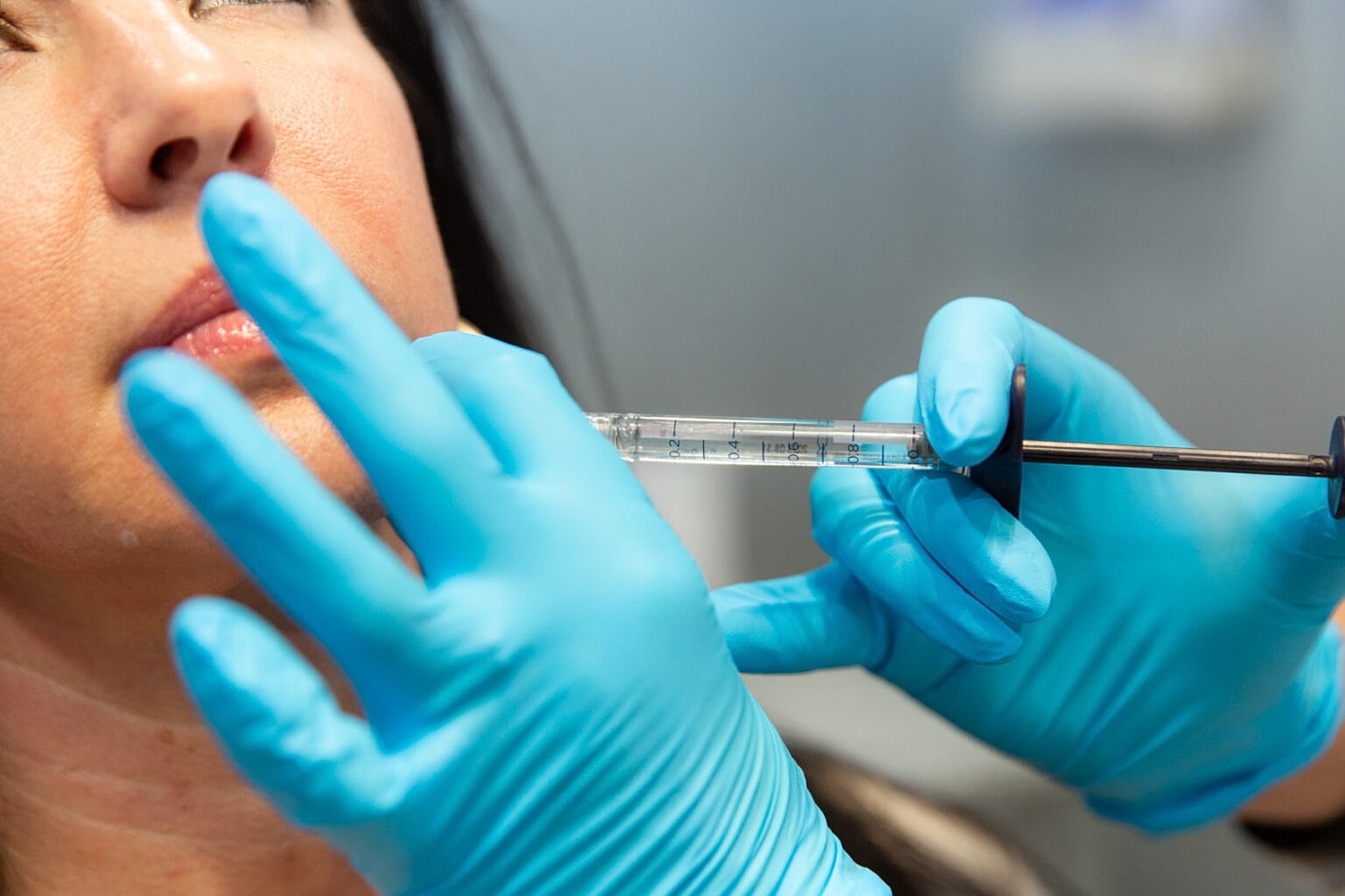 Administering a cosmetic injection to a patient.