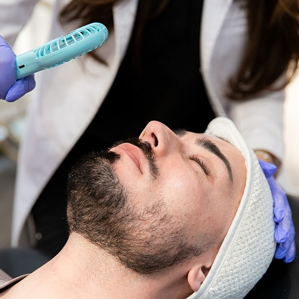 Man receiving facial treatment in a spa.