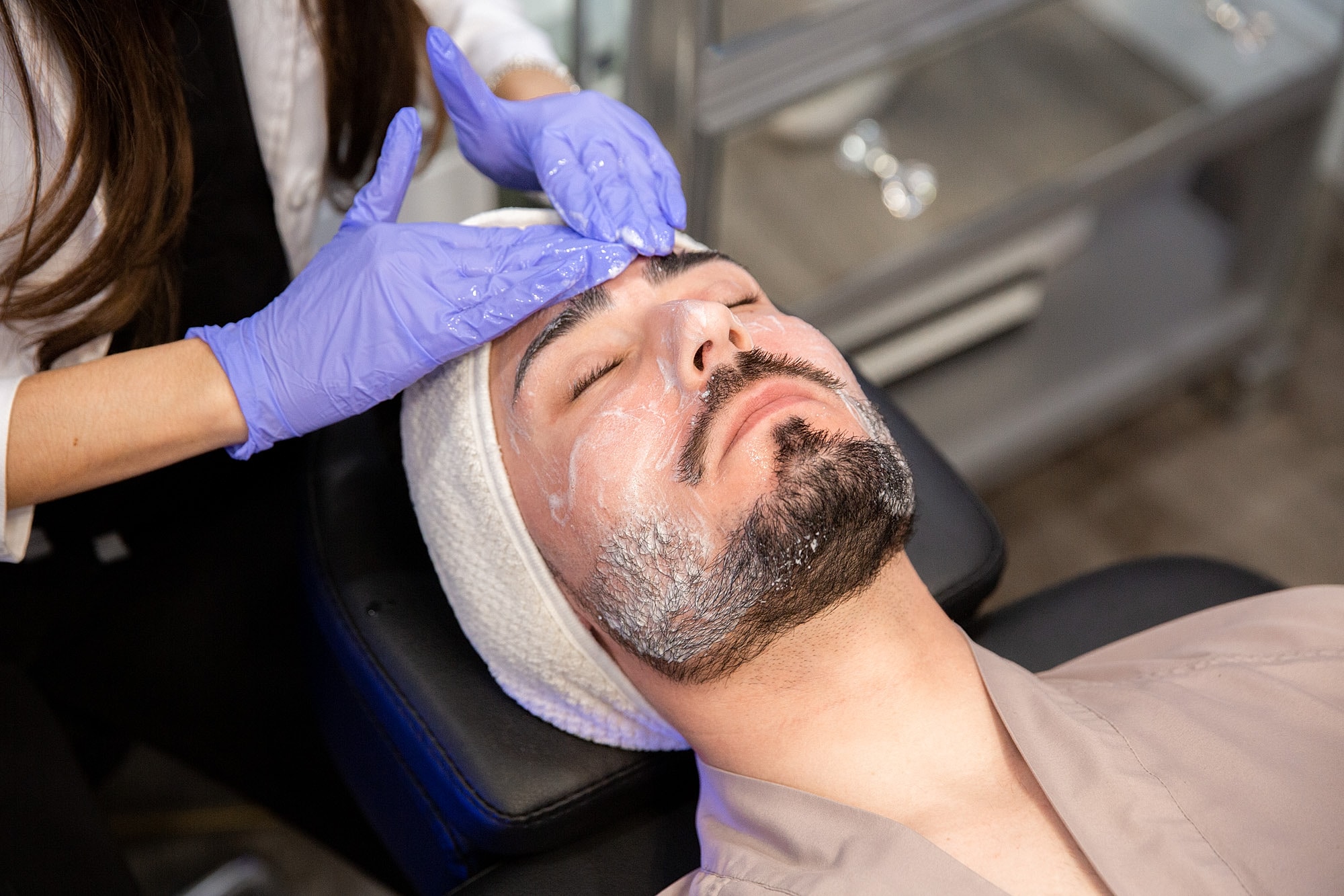 Man receiving a facial treatment at spa.